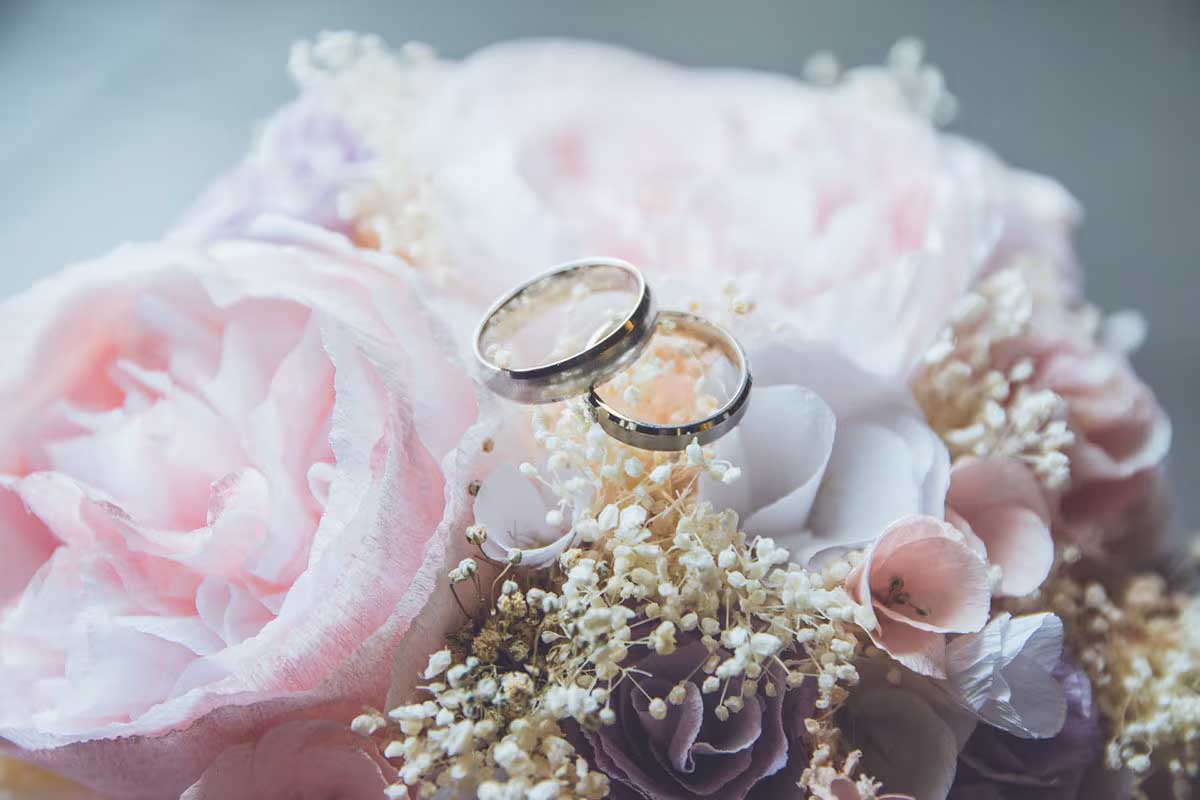 two wedding rights on a bouquet of flowers